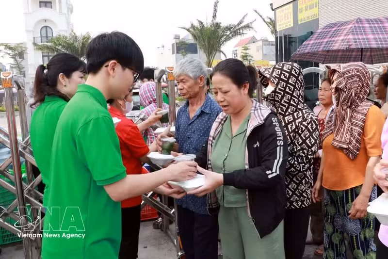 Des élèves du lycée Nguyen Khuyen (quartier de Nam Dinh) offrent des repas aux patients. Photo : VNA.