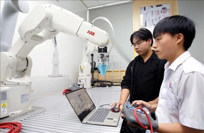 Des étudiants testent des algorithmes de commande d’un bras robotique au laboratoire de robotique de l’Université d’Industrie de Hô Chi Minh-Ville. Photo : VNA.
