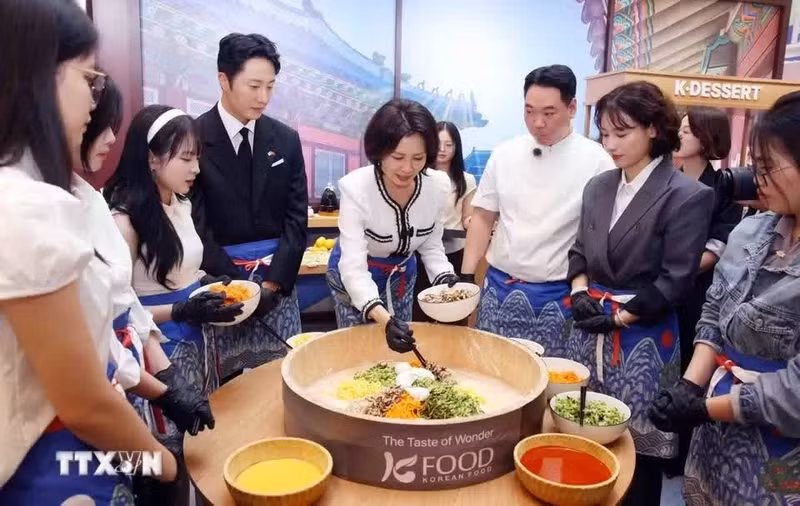 Mme Kim Hea Kyung, aux côtés des délégués, s’initie à la préparation du bibimbap à l’avocat agrémenté de sauce pimentée Gochujang lors du festival organisé à Hanoi. (Photo : Pham Kien/TTXVN)