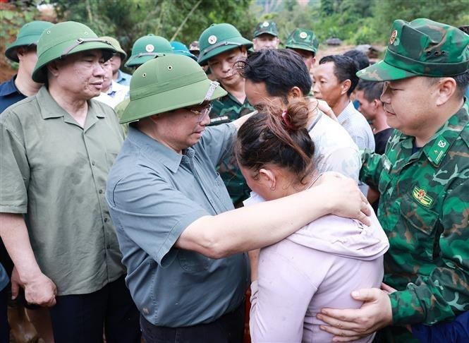 Le Premier ministre Pham Minh Chinh et des sinistrés. Photo : VNA.