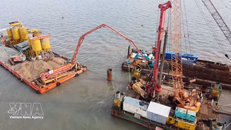 Des ingénieurs et ouvriers travaillent sur le chantier du projet de liaison vers l’île de Hon Khoai. Photo : VNA.
