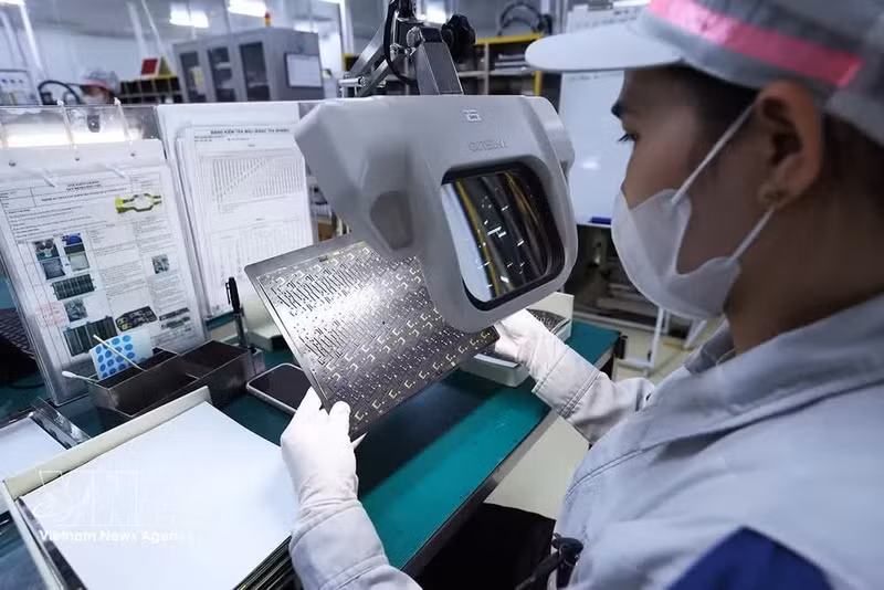 Inspection de cartes de circuits imprimés utilisées dans des appareils électroniques, dans l'usine de Mektec Manufacturing Vietnam Co., Ltd., à 100% de capitaux japonais, dans le parc industriel de Thang Long II, quartier de My Hao, province de Hung Yên. Photo : VNA