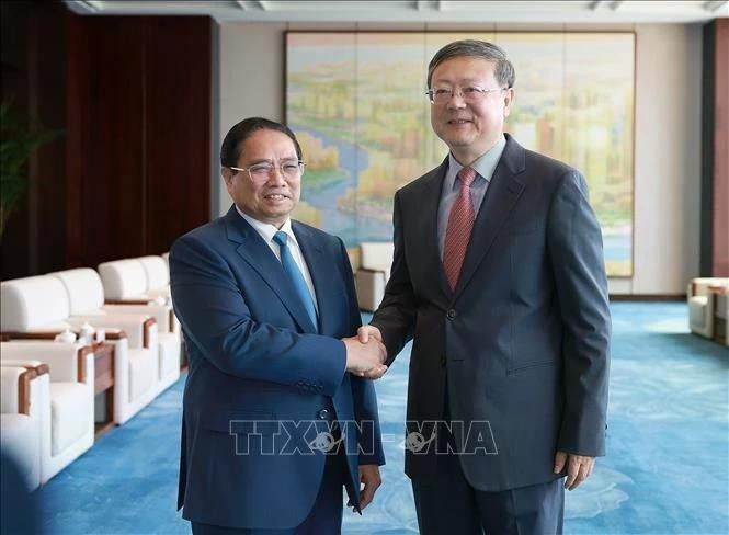 Le Premier ministre Pham Minh Chinh (gauche) et Chen Jining, membre du Bureau politique du Comité central du Parti communiste chinois (PCC) et secrétaire du Comité du PCC pour la ville de Shanghai. Photo: VNA