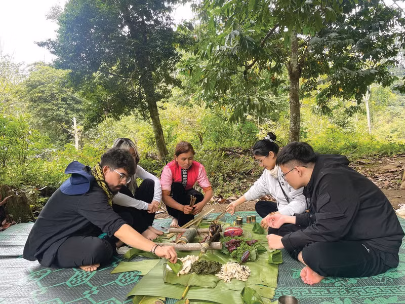 Dang Thi Lan (centre), de l’ethnie Thai, prépare un repas traditionnel destiné aux touristes.