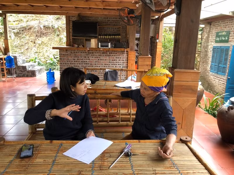 Dinh Thi Huyên, directrice du Centre de coopération pour le développement du Nord-Ouest (TABA) (gauche) discute du plan d'accueil de visiteurs avec Hà Thi Soan, une femme de l'ethnie Thai participant au projet.