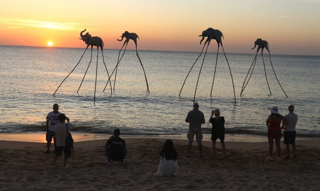 Des touristes contemplent le coucher du soleil sur Bai Truong, île de Phu Quôc. Photo : VNA.