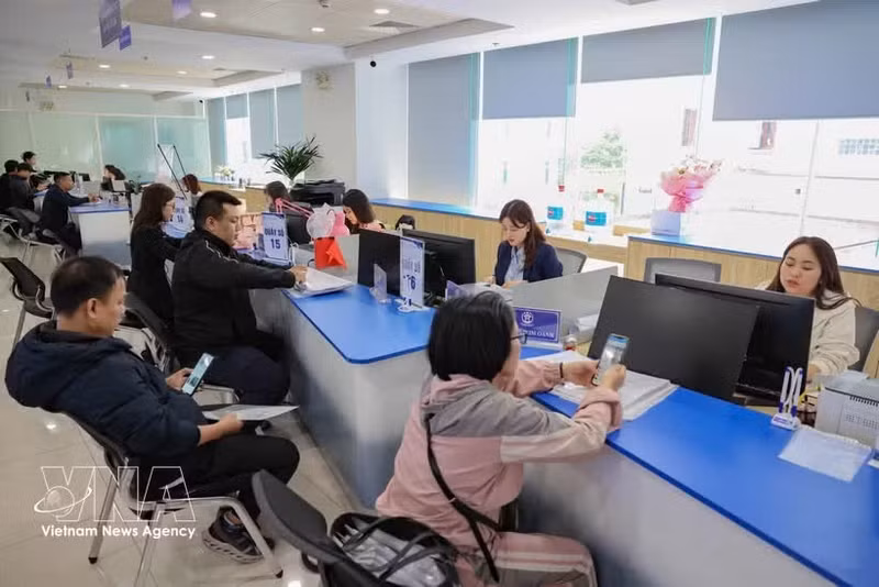 Des gens font les démarches administratives à la filiale de Tây Hô du Centre des services administratifs publics, à Hanoi. Photo : VNA.