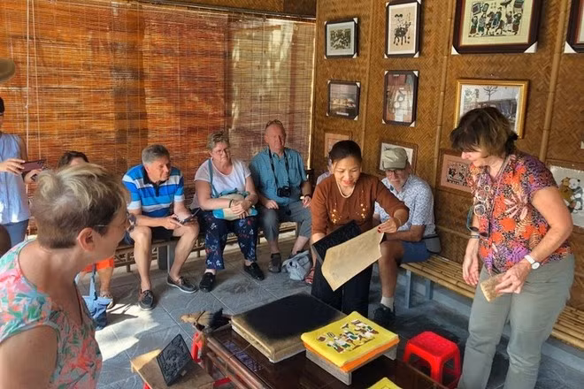 Visiteurs au Centre d'échange d'art populaire Dông Hô de la famille Tam. Photo: gracieuseté de Nguyên Dang Tâm