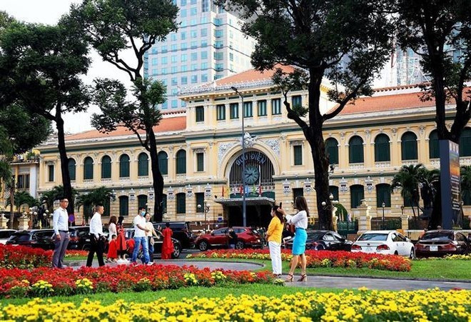Des touristes devant la Poste centrale de Hô Chi Minh-Ville. Photo : VNA.