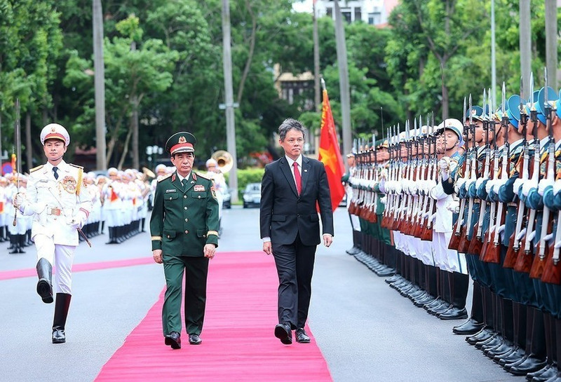 Le général Phan Van Giang, ministre vietnamien de la Défense (gauche), préside la cérémonie d’accueil de son homologue singapourien, Chan Chun Sing, ce mardi matin 22 juillet à Hanoï. Photo : VNA.