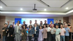 Des représentants d'entreprises vietnamiennes et indonésiennes prennent une photo souvenir avec les organisateurs du forum. Photo : VNA.
