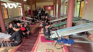 Près d’une dizaine de femmes M’nông Rlăm se réunissent pour tisser des étoffes traditionnelles dans la Maison culturelle communautaire du hameau Lê, commune de Lien Son Lak, province de Dak Lak. Photo : VOV.