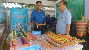 Thạch Rô Si Dol (en chemise bleue) présente sa maquette de ghe Ngo lors de l’événement "Concours de projets de start-up des jeunes ruraux 2023". Photo : VOV.