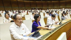 Dans le cadre de la 9ᵉ session de la 15ᵉ législature de l’Assemblée nationale, les députés votent l'approbation de la loi modifiant et complétant certains articles de la Loi sur l’organisation du Parquet populaire. Photo : VNA.