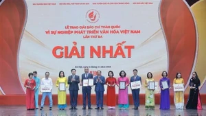 Le vice-Premier ministre Mai Van Chinh (4e, gauche) et le ministre de la Culture, des Sports et du Tourisme, Nguyen Van Hung (6e, gauche), remettent le premier prix aux auteurs et aux groupes d'auteurs lauréats. Photo : VNA.