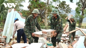 Des soldats du régiment 143 aident les habitants de Hoa Thinh, dans la province de Dak Lak, à dégager les maisons endommagées par les inondations. Photo : VOV.