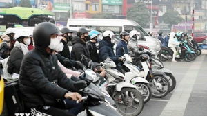 Des habitants respectent les feux de signalisation au carrefour Khuât Duy Tiên – Nguyê Trai, à Hanoï. Photo: VNA