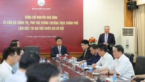 Le vice-Premier ministre permanent, Nguyen Hoa Binh (debout, au micro), prend la parole lors de la rencontre avec des responsables de l’Université nationale du Vietnam à Hanoï. Photo : NDEL.