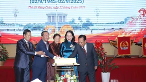 La vice-présidente vietnamienne Vo Thi Anh Xuân et la vice-présidente lao Pany Yathotou ainsi que les délégués découpent un gâteau d'anniversaire lors de l’événement. Photo : VNA