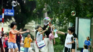 Des enfants jouent dans la zone piétonne autour du lac de l’Épée restituée, à l’occasion de la Fête nationale (2 septembre). Photo : VNA.