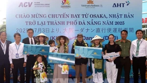 Lors de la cérémonie d'accueil, le comité d'organisation a offert des fleurs et des cadeaux à trois heureux invités du vol VN337 Osaka-Da Nang. Photo : VNA.