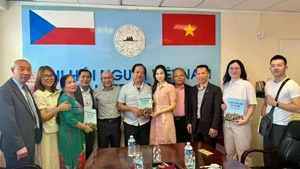 Le traducteur Nguyen Quyet Tien (6e de la gauche) offre au Centre de langue vietnamienne la collection de dictionnaires et de conversations vietnamien-tchèque-anglais qu’il a lui-même rédigée. Photo : VNA.