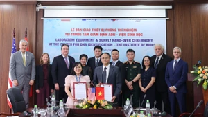 Des représentants de l’Institut de biologie (VAST) et de l’ICMP échangent les documents de remise des équipements du projet. Photo : thoidai.com.vn