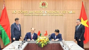 Le ministre vietnamien de la Sécurité publique, le général Luong Tam Quang (droite) et le secrétaire d'État du Conseil de sécurité de la Biélorussie, Volfovich Aleksandr Grigorievich signent un protocole d'accord portant création d'un groupe de travail conjoint visant à élargir et à renforcer la coopération en matière de sécurité. Photo : VNA