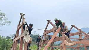 Les forces de la police et de la milice apportent leur soutien aux habitants dans la construction de logements à l’approche de la nouvelle année. Photo : VNA.