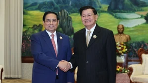 Le Premier ministre Pham Minh Chinh et le secrétaire général du Parti révolutionnaire populaire lao et président du Laos, Thongloun Sisoulith se serrent la main, à Vientiane, le 3 décembre. Photo : NDEL.