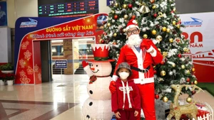 Dès le quai, l’ambiance de Noël se fait sentir : les employés du secteur ferroviaire se déguisent en Père Noël et offrent des cadeaux aux enfants voyageant en train. Photo : tienphong.vn