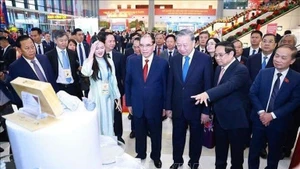 Le Secrétaire général du PCV To Lam, le Premier ministre Pham Minh Chinh et de nombreux autres dirigeants du Parti et de l'État visitent le stand de Masan High-Tech Materials. Photo : NDEL.