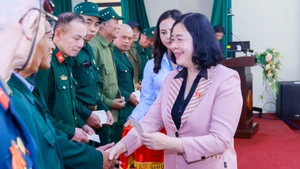 La présidente du Comité central du Front de la Patrie du Vietnam (FPV), Bui Thi Minh Hoai, remet des cadeaux aux vétérans des communes de Phu Dông, Bat Trang, Gia Lâm et Thuân An, à Hanoï. Photo: VNA.
