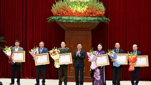 Tran Cam Tu (au centre) remet l’Ordre du Travail de première classe du président de la République aux unités ayant accompli des réalisations exceptionnelles en matière de conseil, d'organisation et de service du XIVe Congrès du Parti. Photo : NDEL