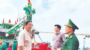 Un cadre du poste frontière de Thanh Hai (province de Lam Dong) et un représentant du comité populaire du quartier de Phu Thuy sensibilisent les pêcheurs à la préparation des élections. Photo : NDEL.