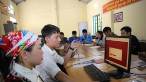 Instructions aux résidents du village de Son Ha, commune de Bat Xat, sur la manière de soumettre des demandes en ligne via le portail des services publics. Photo: VNA