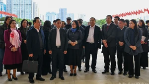 Le permanent du Secrétariat, Tran Cam Tu, et des délégués inspectent les préparatifs du XIVe Congrès national du Parti au Centre national des conférences. Photo : NDEL.