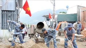70 soldats sont mobilisés simultanément sur les quatre bâtisses afin de reconstruire les habitations détruites par les inondations. Photo : VNA.