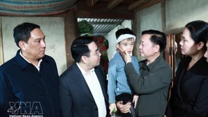 Le vice-Premier ministre Tran Hong Ha (2e de droite) rend visite à l'enfant rescapé du naufrage. Photo : VNA.