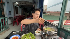 Jongrak déguste la fondue vietnamienne à la sauce de poisson à Hô Chi Minh-Ville. Photo : HanQuocBros