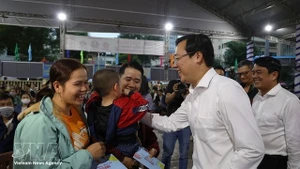 Lê Quôc Phong, secrétaire adjoint permanent du Comité du Parti de Hô Chi Minh-Ville, distribue des cadeaux aux travailleurs avant leur départ en bus pour rentrer chez eux le 12 février. Photo : VNA.