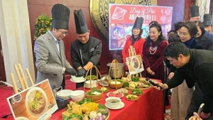 Des invités ont l'occasion de découvrir comment est préparé un bol de Phở. Photo : baoquocte.vn