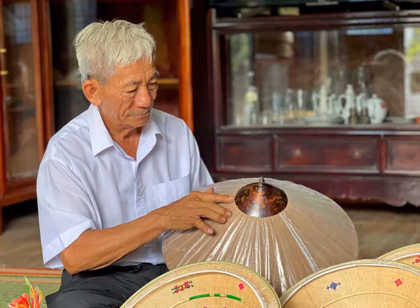 L'artisan Do Van Lan, plus connu sous le nom de Ba Lan, âgé de 80 ans et résidant au village de Phu Gia, conserve une remarquable collection de « nón ngựa » anciens. Photo : TPO.