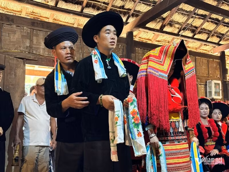 Les mariés dao rouge se tiennent devant l’autel des ancêtres, tandis que le maître de cérémonie et ses deux assistants accomplissent les rites pour le mariage. Photo : Vietnamnet.