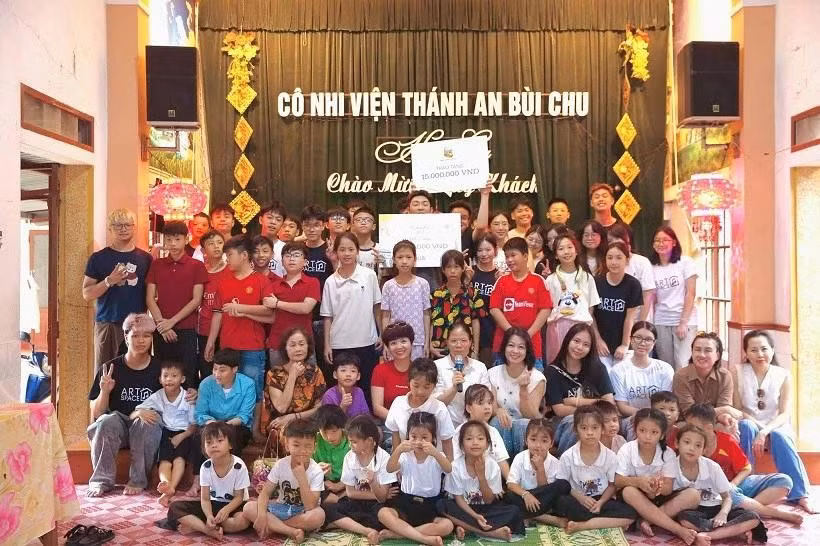 Des membres du projet Toucher Arts remettent directement des cadeaux aux enfants en situation difficile de l’orphelinat Thanh An-Bui Chu. Photo : baoquocte.