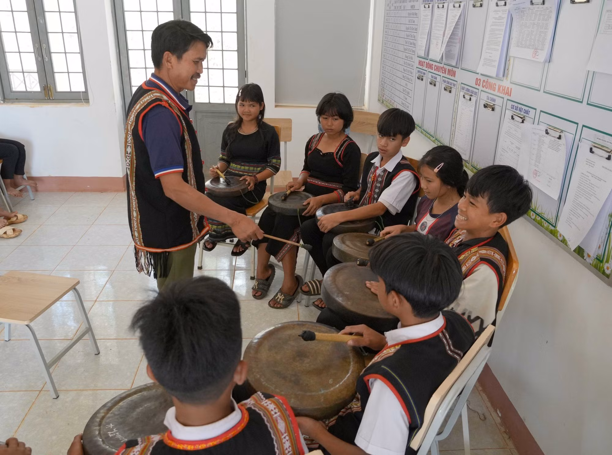 L'Artisan émérite A Thu dispense un cours consacré aux gongs aux élèves du collège Dang Thuy Tram, dans la commune de Kon Dao, province de Quang Ngai. Photo : baotintuc.