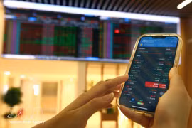 Des clients effectuent des transactions au siège de la société boursière Bao Viet. Photo : VNA.
