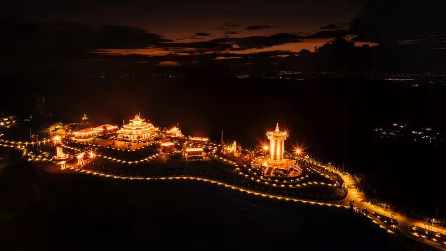 À la tombée du jour, Samten Hills Dalat s’illumine tandis que les dernières lueurs du soleil disparaissent et que la nuit enveloppe les collines.
