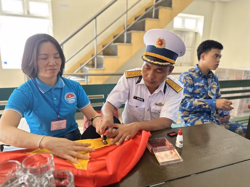 Un Vietnamien d’outre-mer en Pologne a respectueusement apposé le sceau de l’île Da Tay B sur le drapeau national en souvenir. Un Vietnamien d’outre-mer en Pologne a respectueusement apposé le sceau de l’île Da Tay B sur le drapeau national en souvenir.