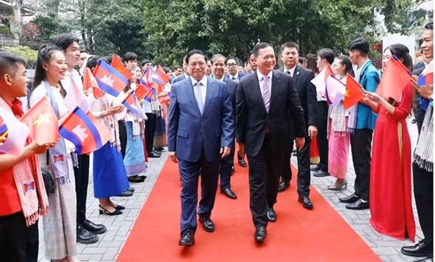 Les Premiers ministres Pham Minh Chinh (à gauche) et Samdech Moha Bovor Thipadei Hun Manet visitent l’Université du commerce extérieur à Hanoï. Photo : VNA.